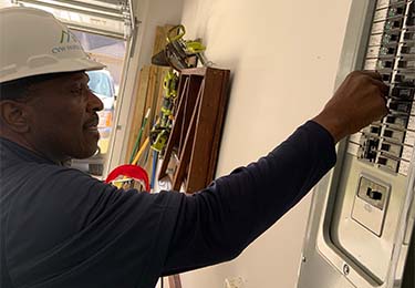 Clarence Williams inspecting an electrical panel.